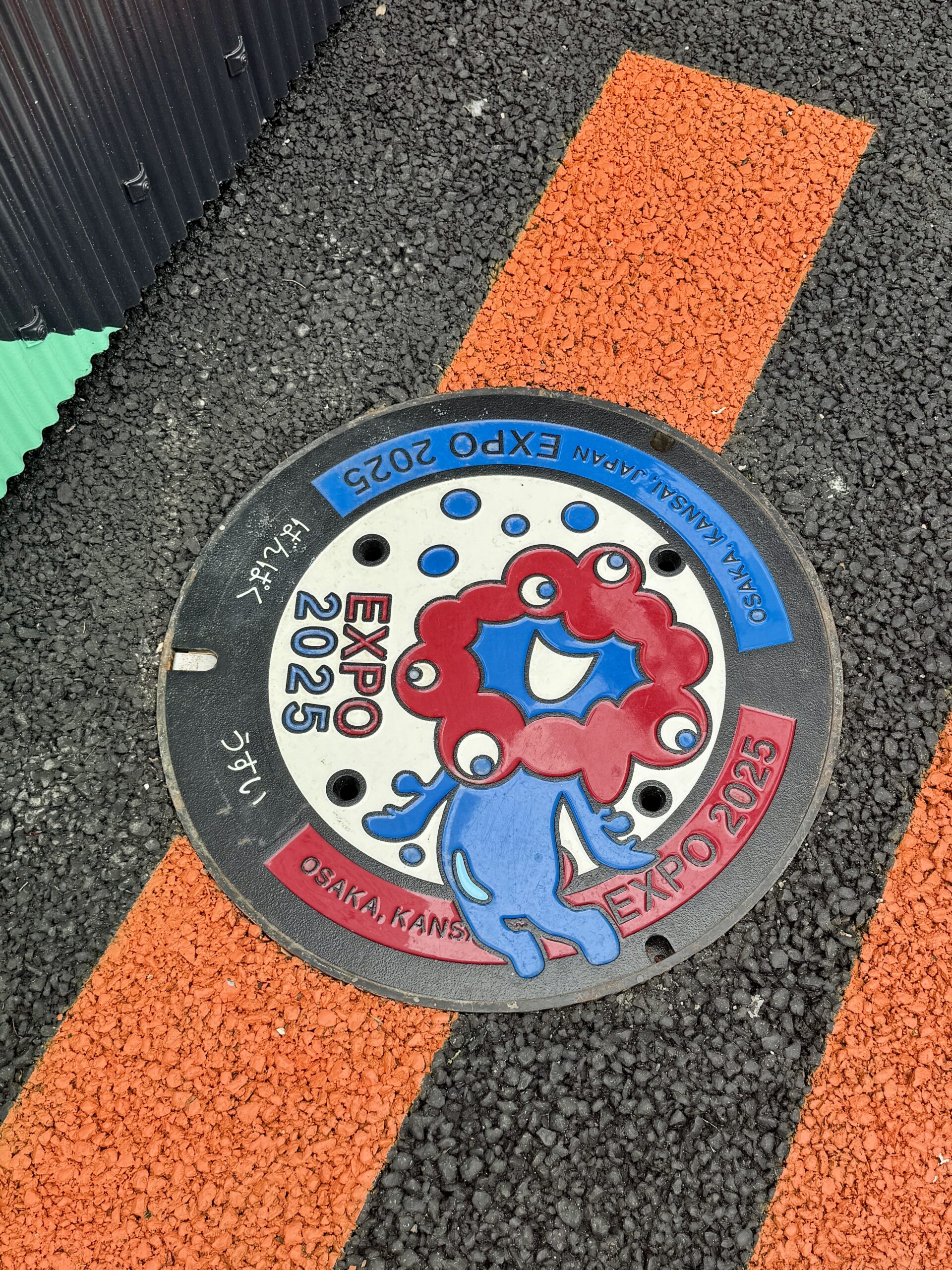 大阪万博2025 ミャクミャクのカラフルマンホールと靴構図の写真